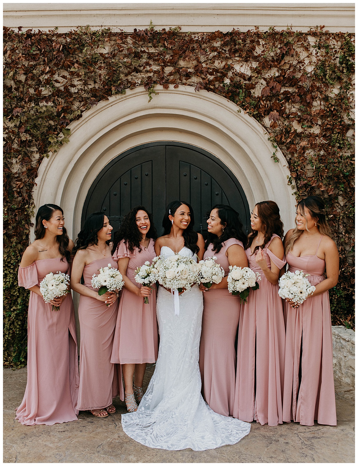 bridesmaids look toward bride while holding florals by Stephanie J. Zamora Photography