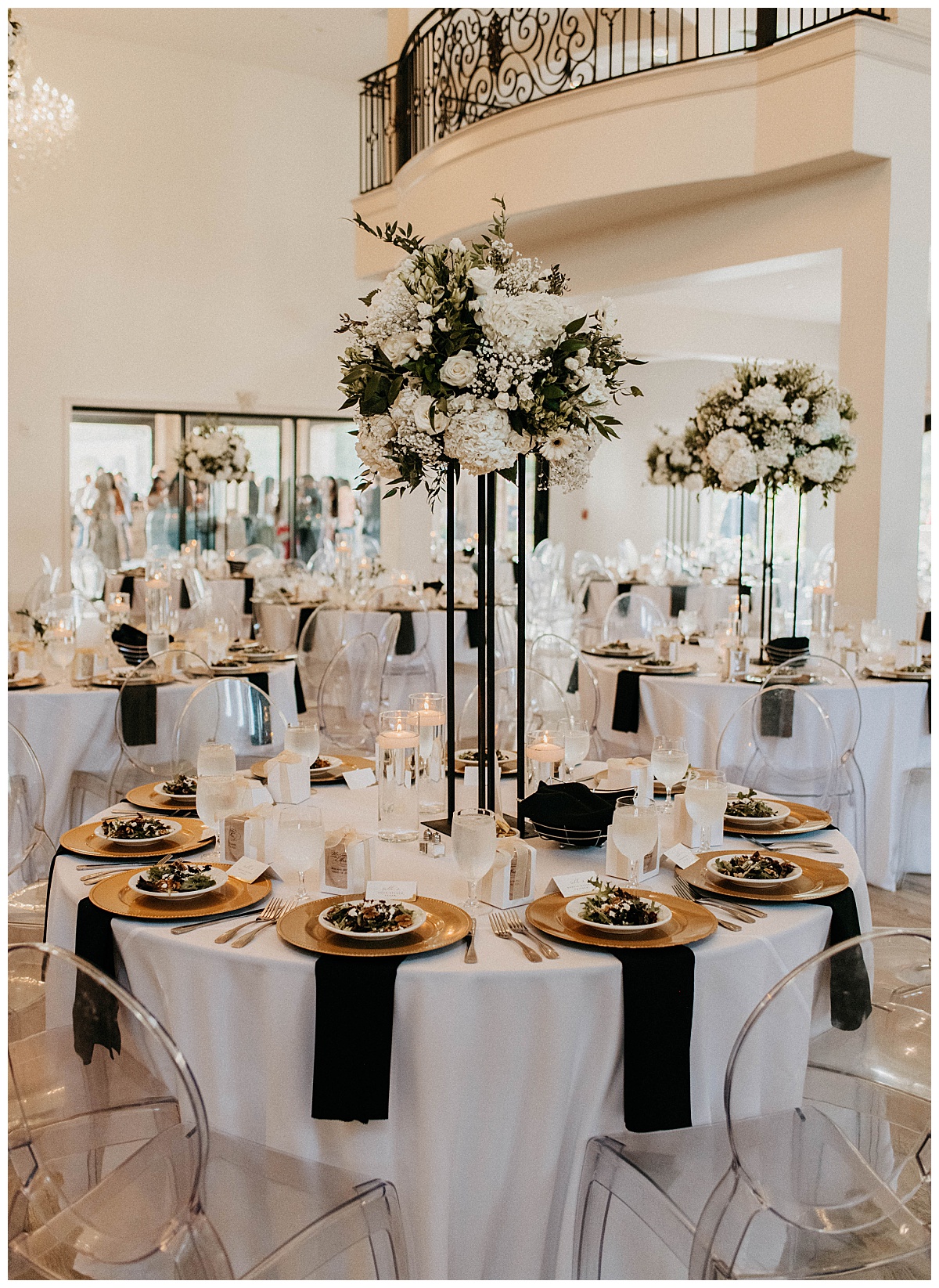 reception tables set with salads, black napkins, and candles at Knotting Hill Place