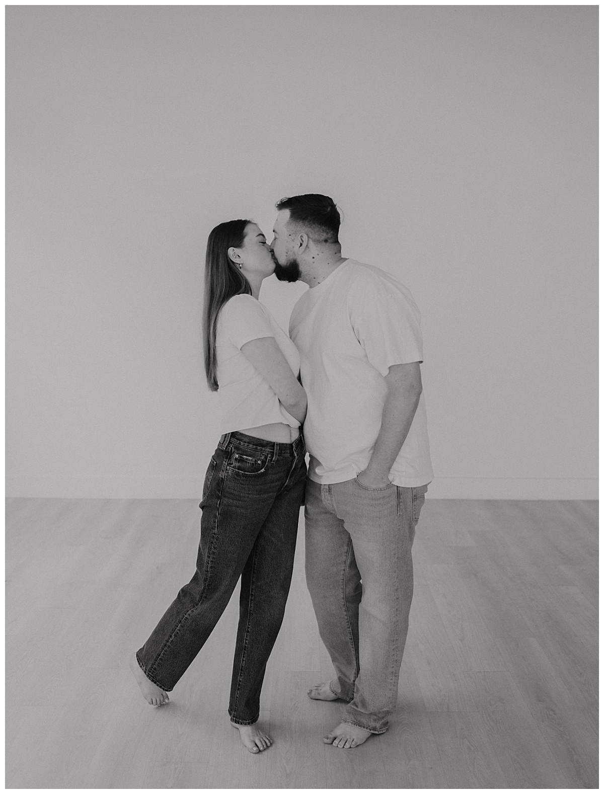 couple wearing jeans and white shirts kisses by Stephanie J Zamora Photography