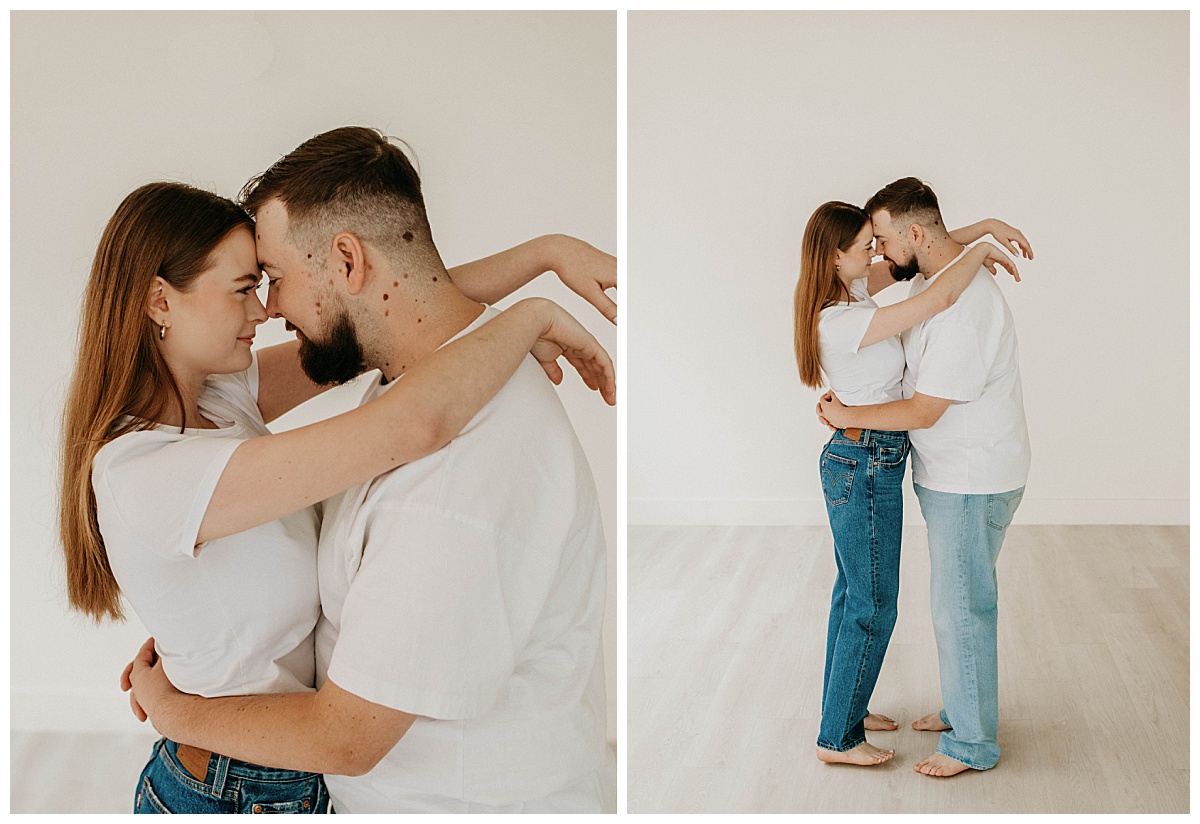 woman puts arms on man's shoulders as they lean together during their studio engagement session