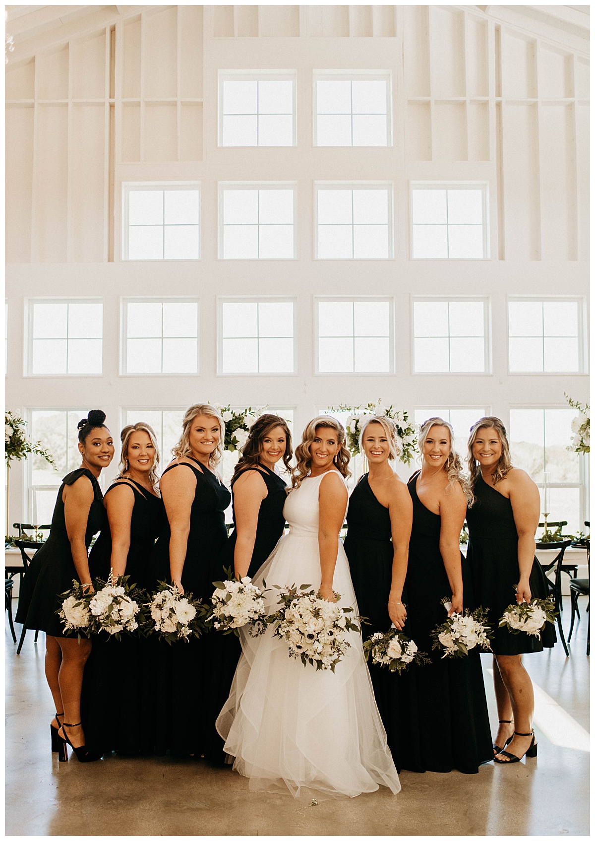 bridesmaids hold bouquets together in front of large windows by Stephanie J Zamora Photography